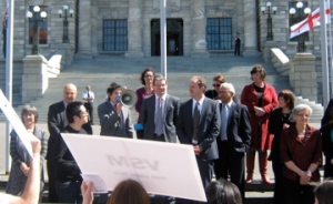 Gareth Hughes speaking, flanked by Green & Labour MP's
